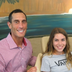 Dr. Cruz poses with a young patient in an exam chair.